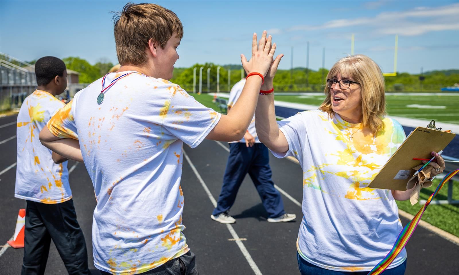 A teacher high fives a student